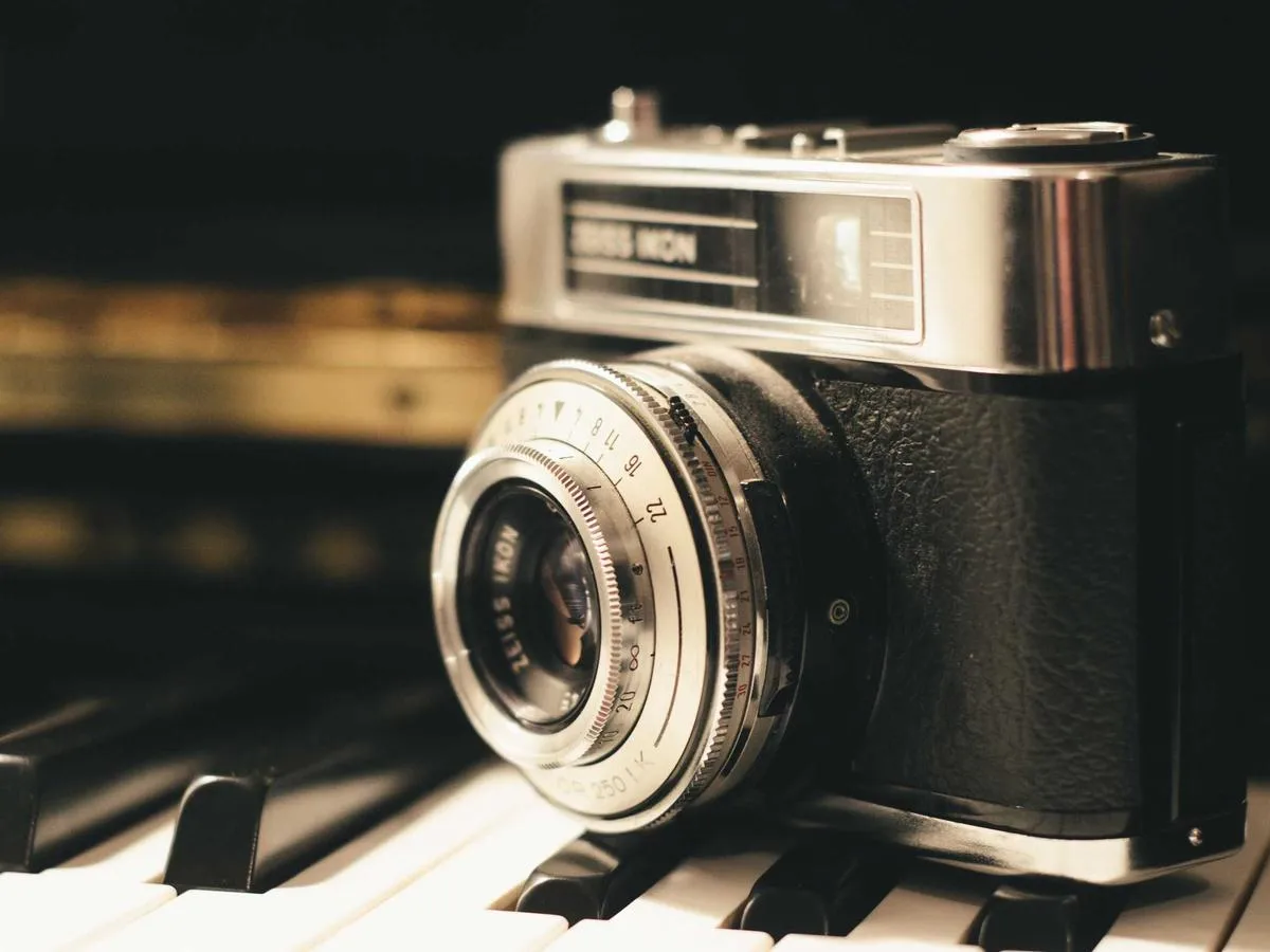A vintage camera and lens resting on a dark surface